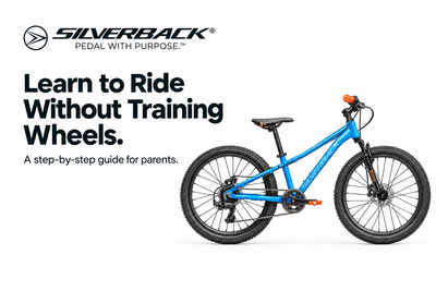 Blue Silverback Spyke 24D kids bike with orange grips beside the Learn to Ride Without Training Wheels heading and Silverback logo on white.