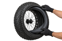 Illustration of gloved hands fitting a fatbike inner tube into a Vee Bulldozer tyre 2