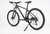A black mountain bike with a black frame, black tires, and a black kickstand, photographed on a seamless white studio background.
