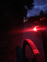 Lifestyle shot of Spectrum Rear Light 2 mounted on a bicycle during nighttime